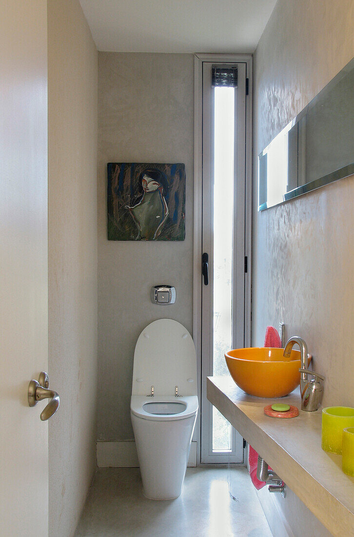 Narrow bathroom with an irregular concrete counter ceramic basin and Ferrum toilet