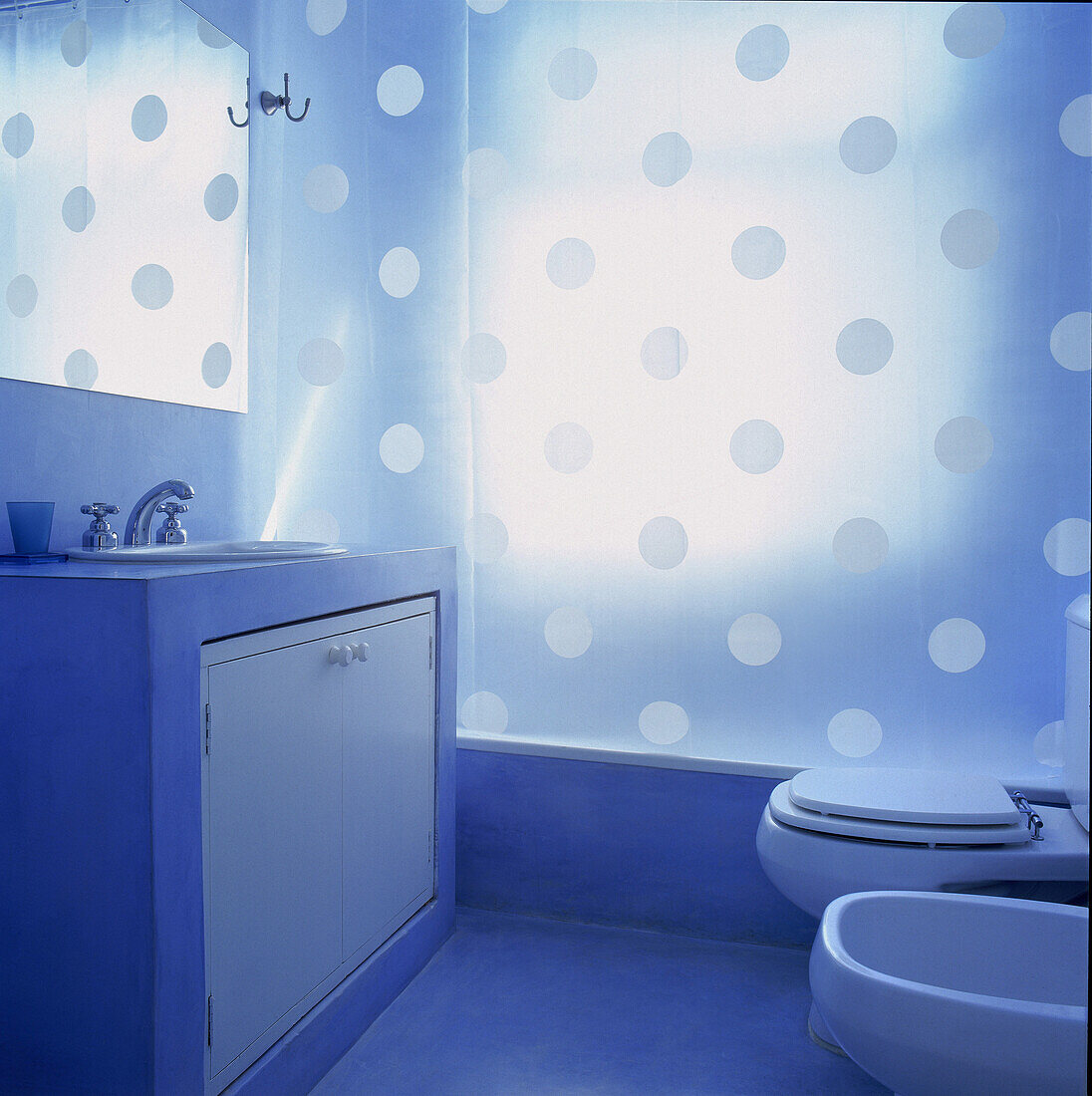 Badezimmer mit Waschbecken in Betonstruktur mit lichtdurchlässigem Duschvorhang