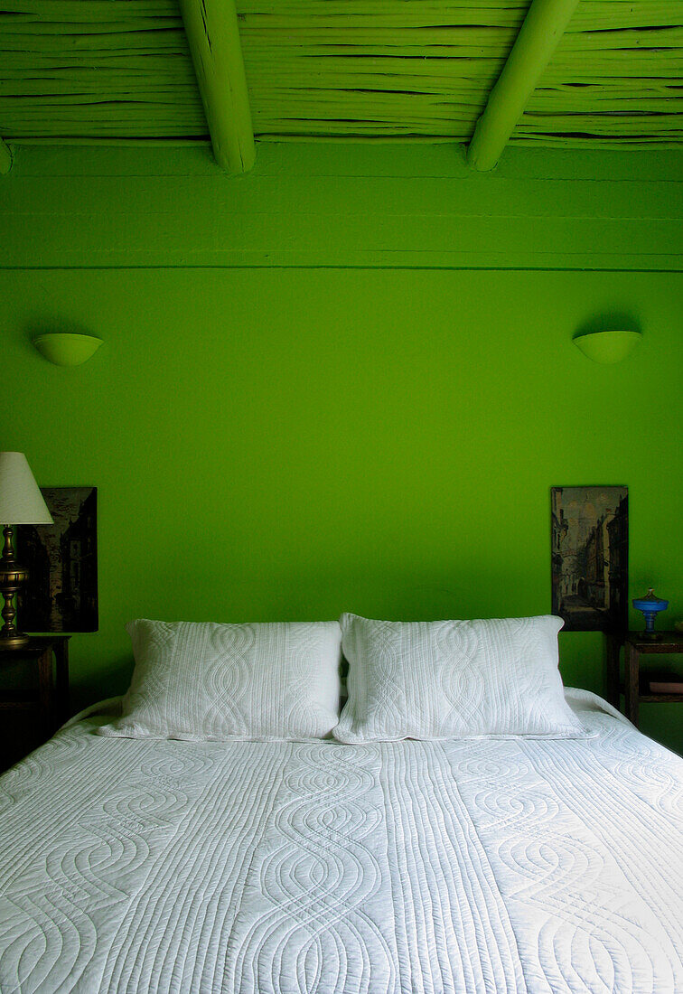 Bettdecke in einem grün gestrichenen Schlafzimmer