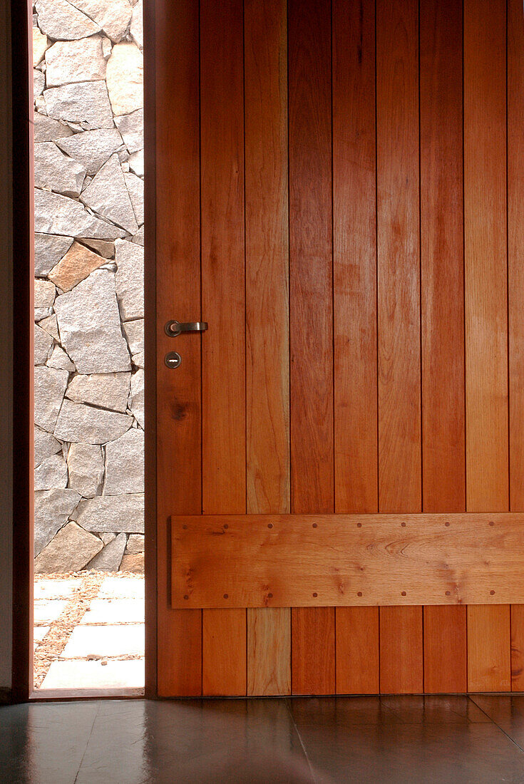 Holzgetäfelte Tür und freigelegte Steinmauer