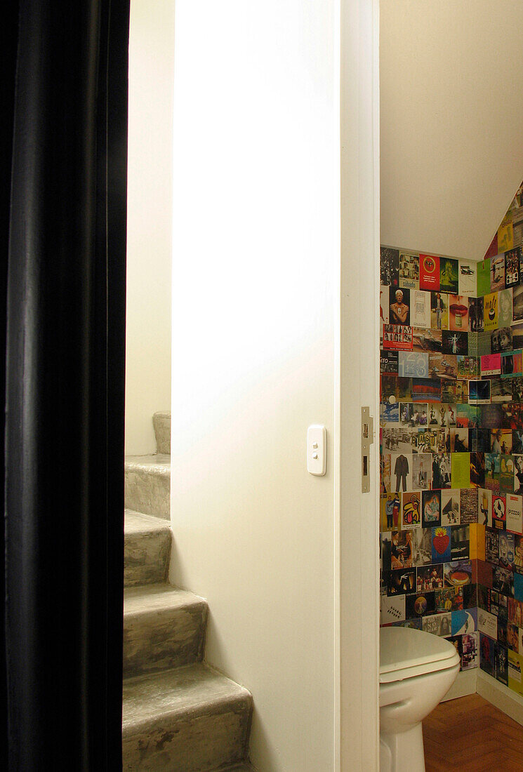 Zementtreppe und Badezimmer unter der Treppe, ausgekleidet mit verschiedenen Postkarten