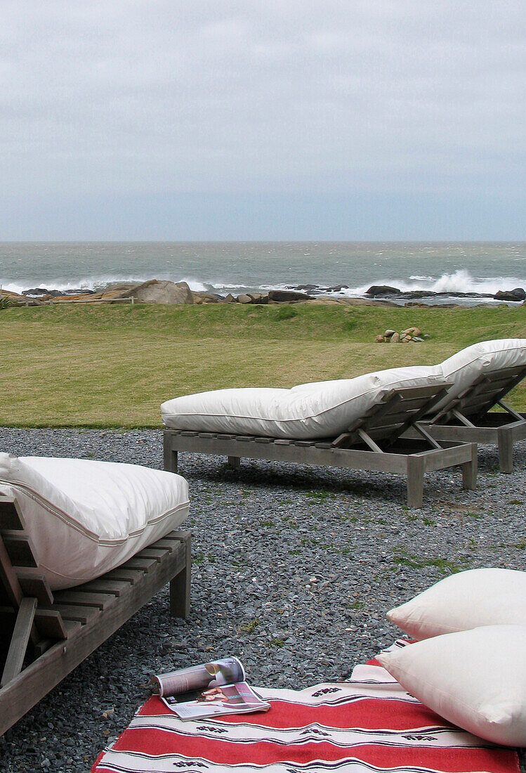 Strandhaus an der Küste - Sonnenliegen auf der gekiesten Veranda