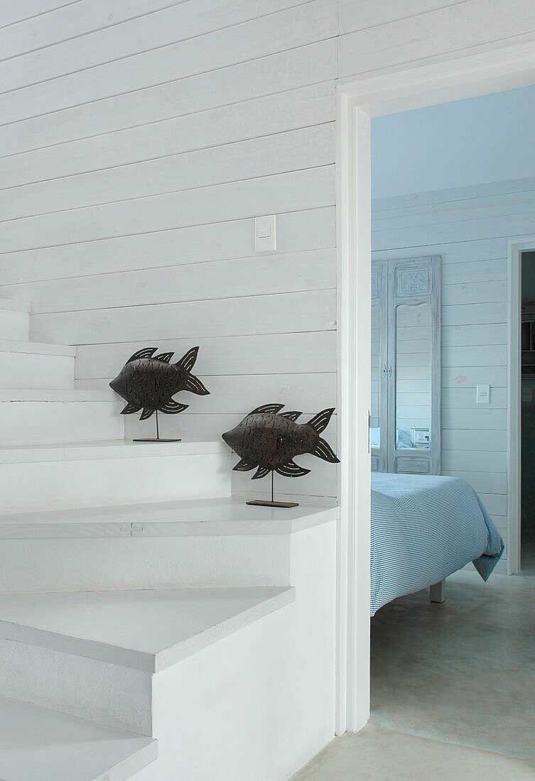 Fischskulpturen auf weiß gestrichener Treppe