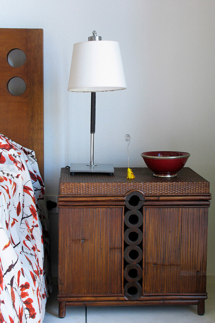 Lamp on nightstand with carved headboard