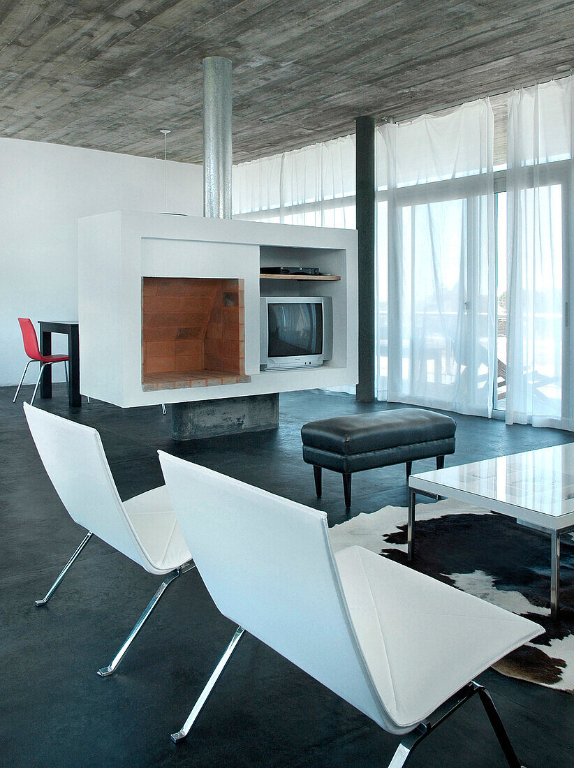Passende Stühle im Wohnzimmer mit erhöhtem Ofen und geglättetem Betonboden