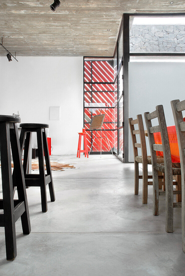 Dining chairs and stools on concrete flooring with cow hide rug