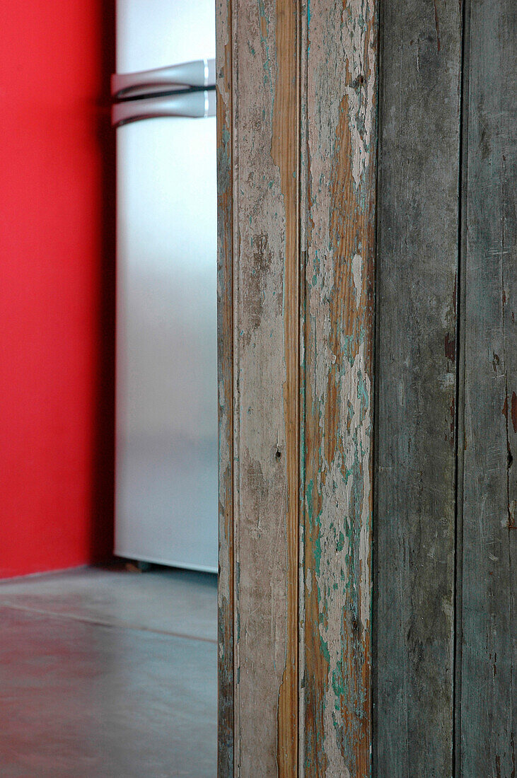 Recycelte Küchentheke mit Kühlschrank und verputzten, rot gestrichenen Wänden