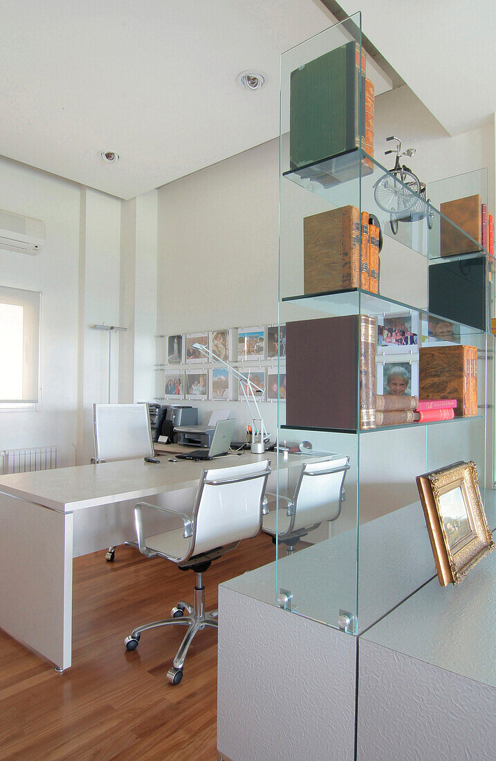 Weißes Arbeitszimmer mit Glasregal