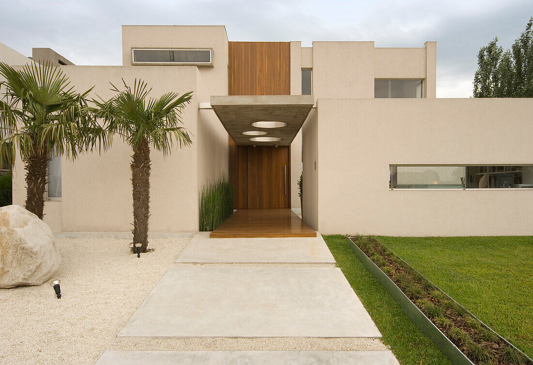 Moderne Gebäudefassade mit Palmen und holzgetäfelter Eingangsveranda