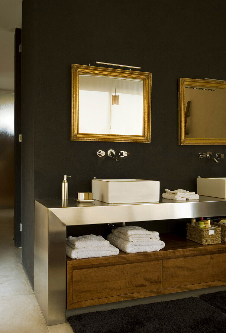 Black en suite bathroom with under sink storage and gilt framed mirrors