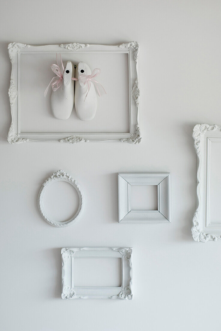 White painted picture frame display mounted with mannequin's feet