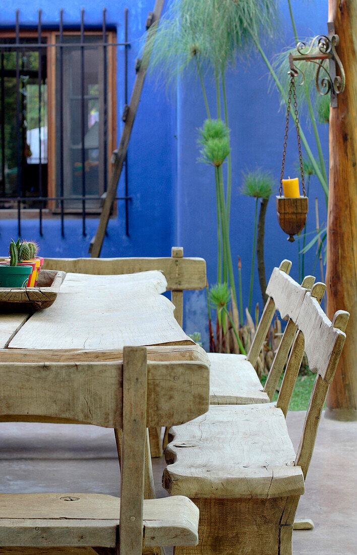 Tisch und Sitzbank aus Eichenholz in einem Garten mit bemalter Veranda im Innenhof