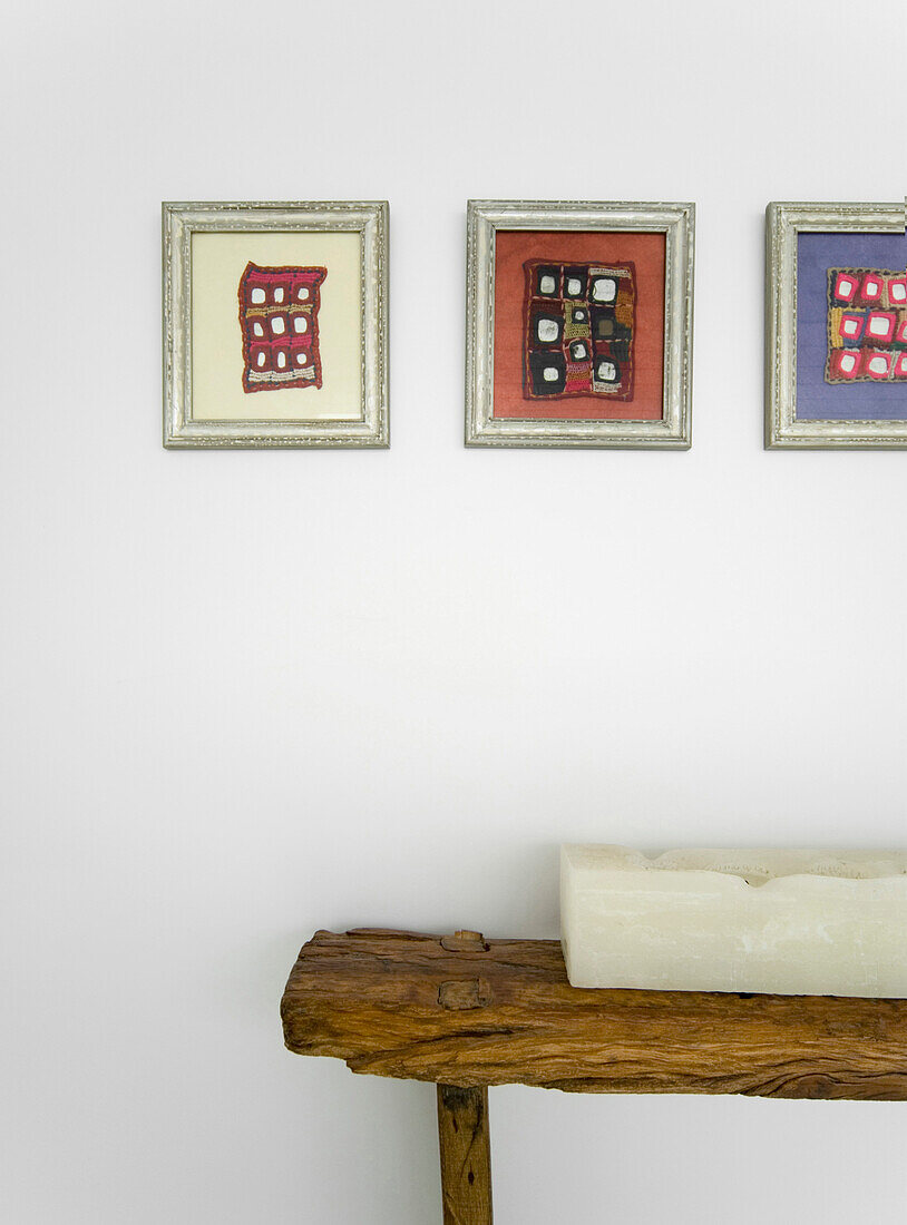 Framed artwork above candle on salvaged wooden bench