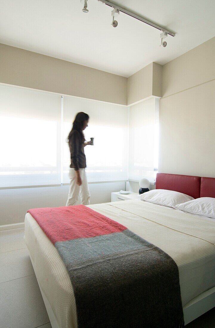 Woman standing in modern bedroom, Palermo, Buenos Aires, Argentina