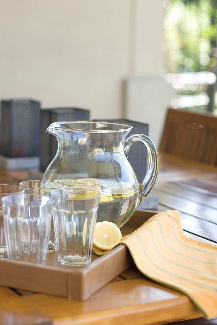 Close up of jug with water and slices of lemon on patio table, Pillar, Buenos Aires, Argentina