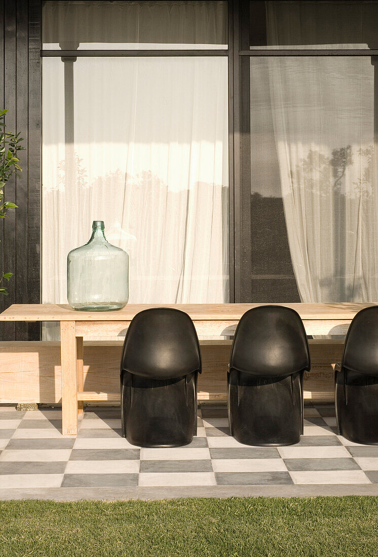 Louis Panton Stühle an einem Holztisch mit Wasserbehälter und Vorhangfenster