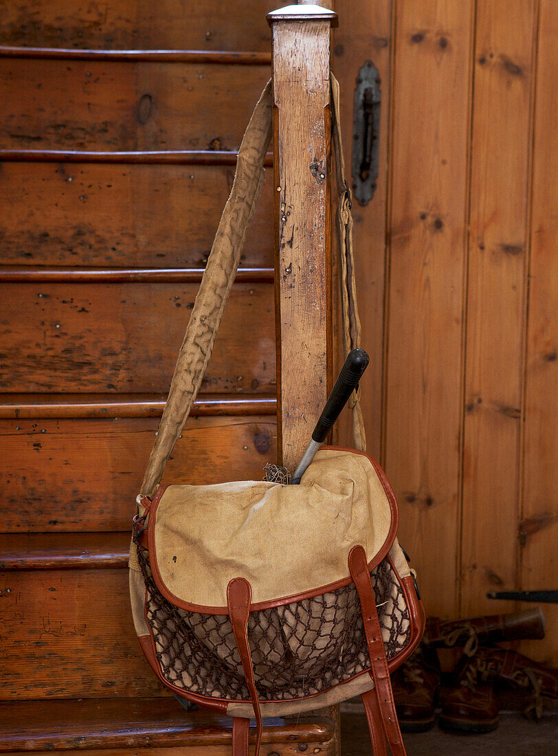 Werkzeugtasche hängt am unteren Ende einer Holztreppe