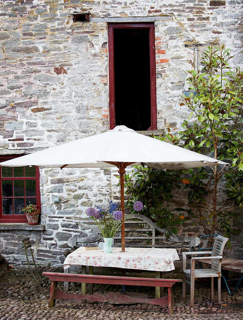 Parasol shades table outside stone building exterior