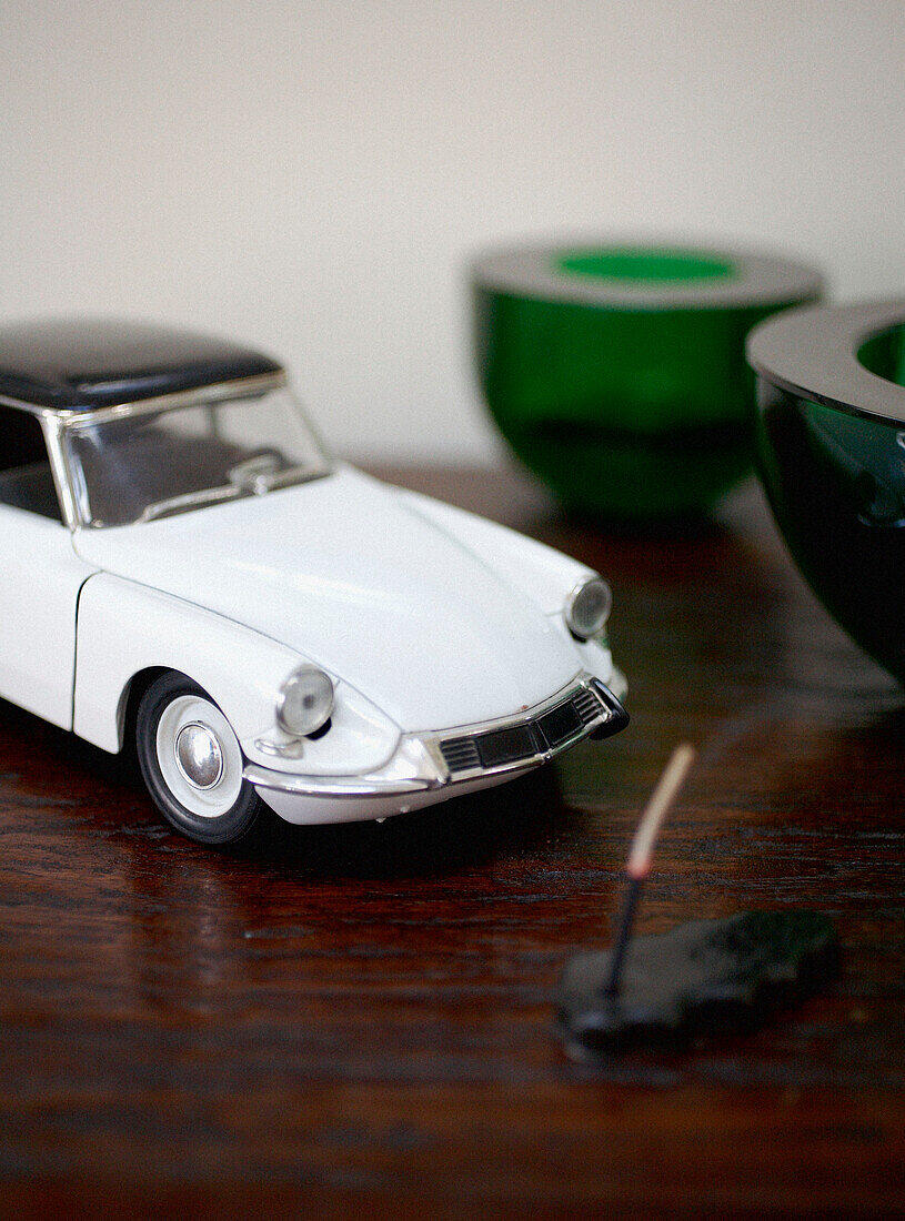 Oldtimer-Spielzeugauto und Teelichthalter aus grünem Glas
