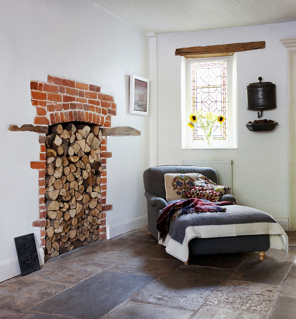 Feature fireplace with grey day bed from Conran on flagstone floor
