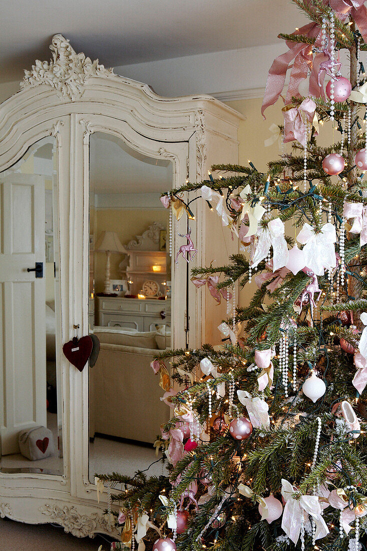 Christmas tree with pink decoration and mirrored wardrobe