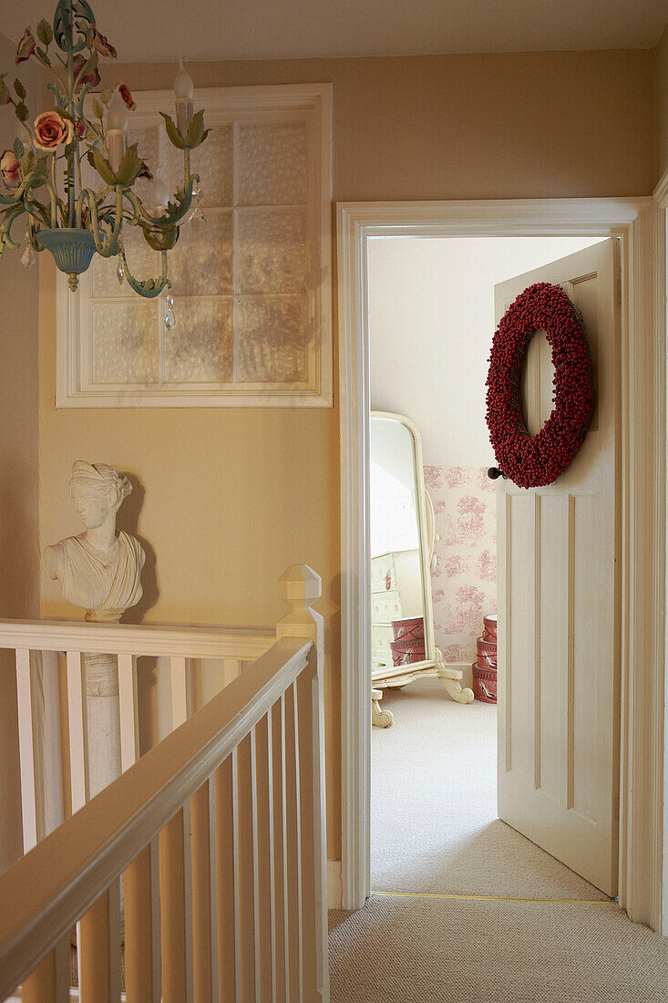 Christmas wreath on bedroom doorway opening from staircase landing 