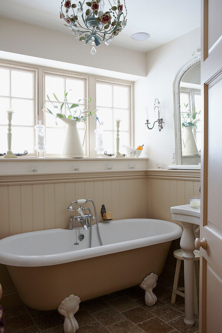 Roll top bath below sunlit bathroom window