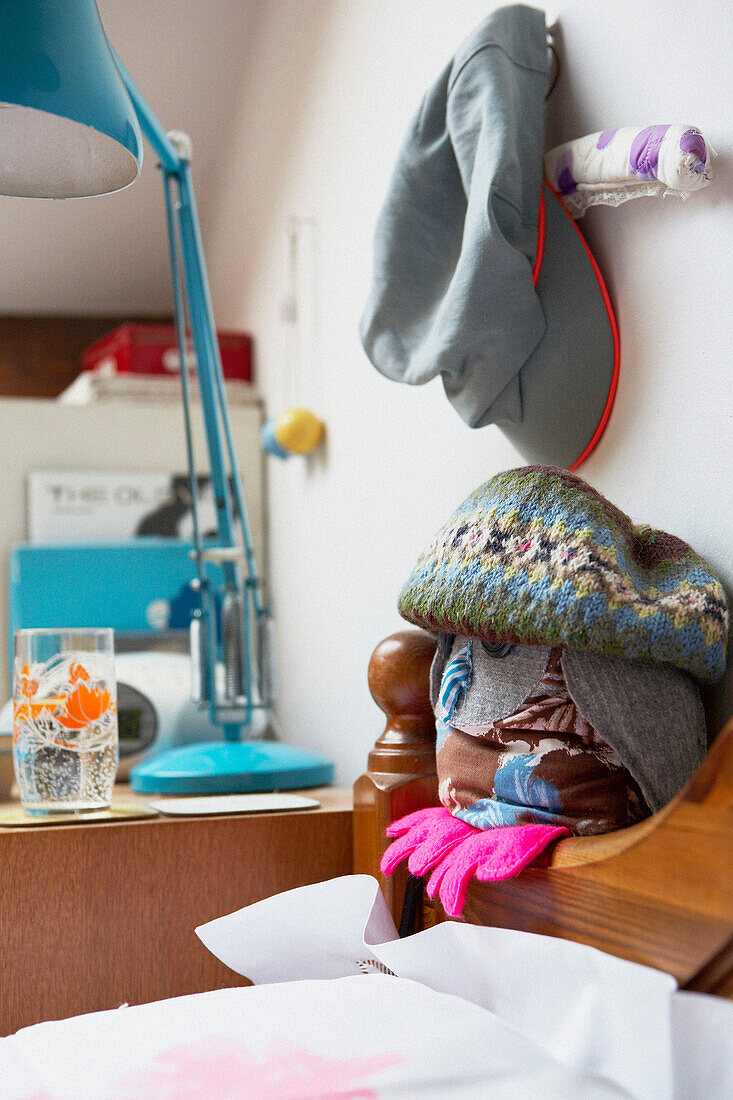 Collection of hats on a headboard with a turquoise desk lamp