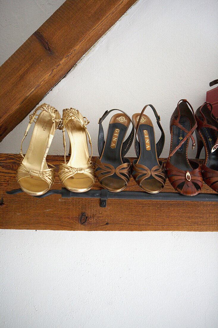 Detail of high heeled ladies shoes in a row on a shoe rack