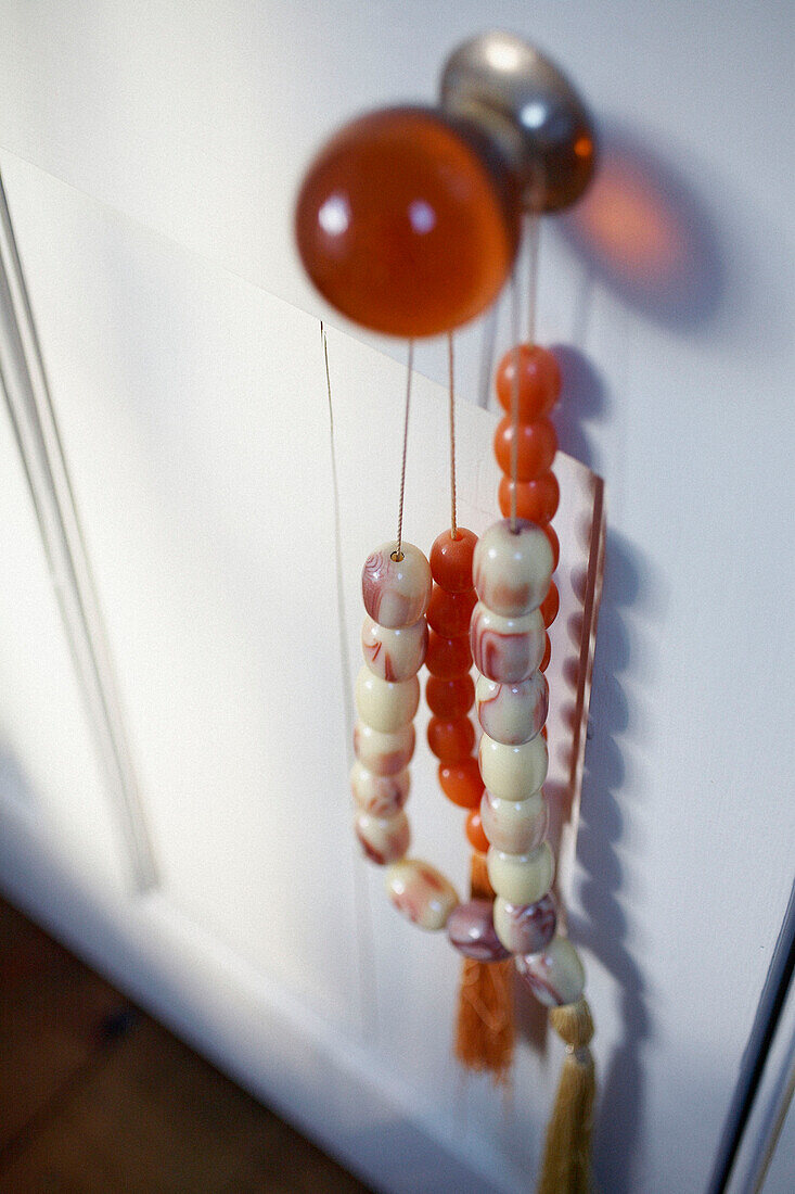 Oranger Glastürknopf mit Perlen