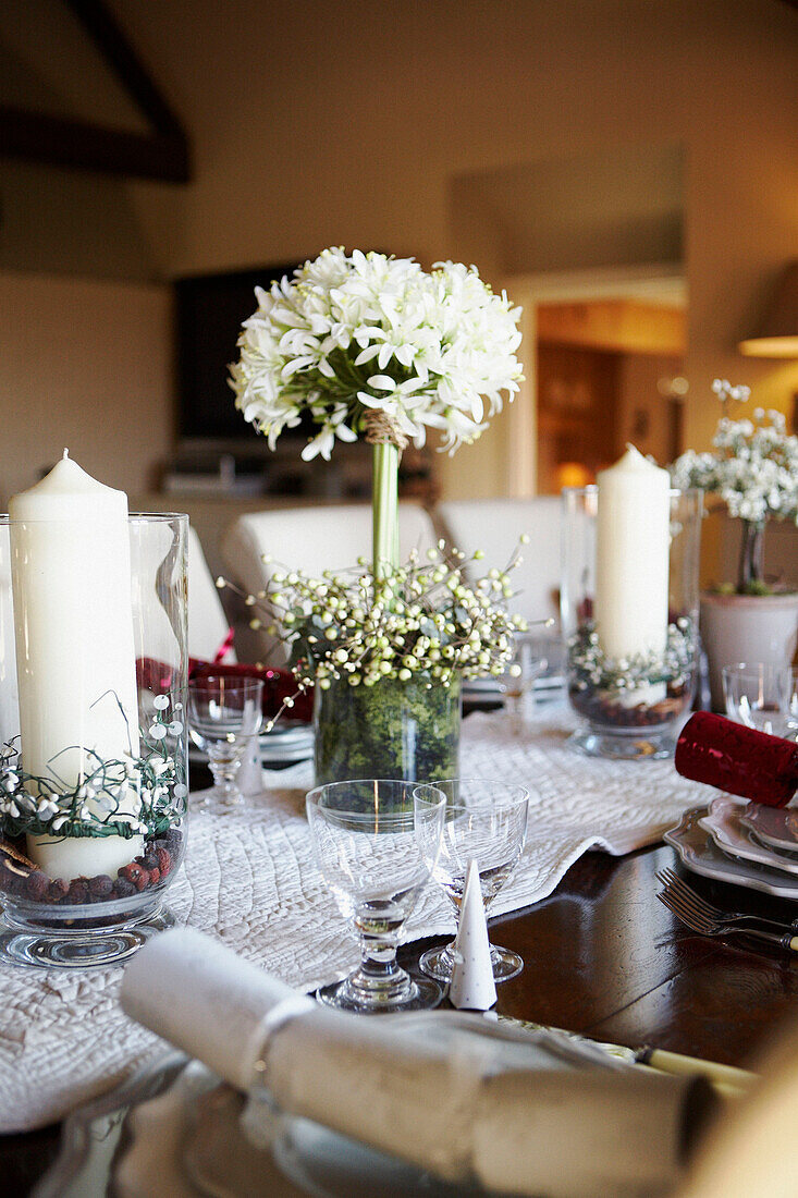 White centrepiece and table runner on table set for Christmas dinner