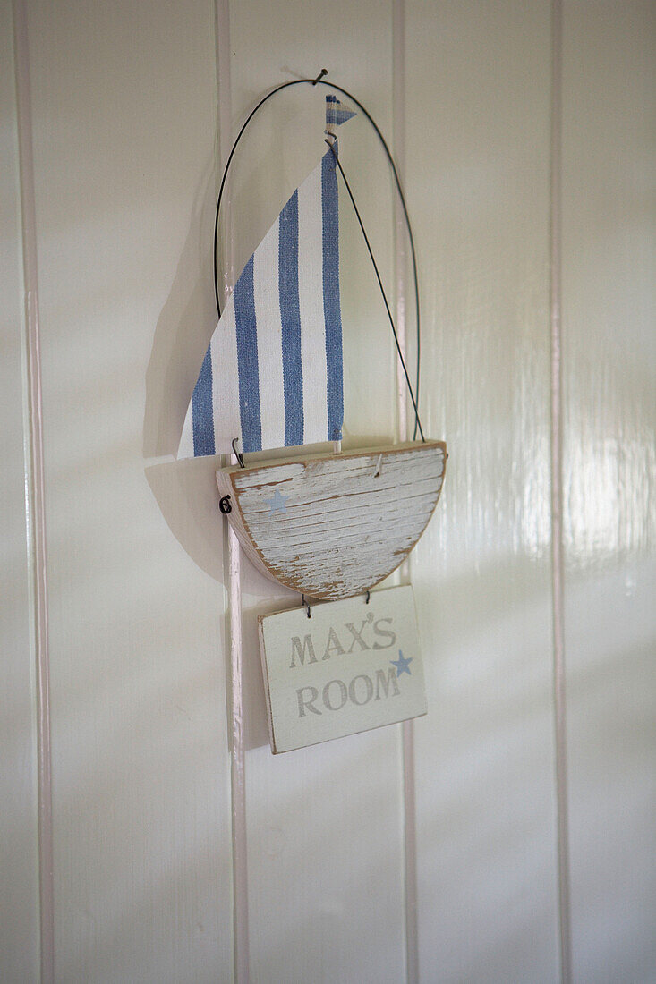 Panelled door of boys room with boat and name sign