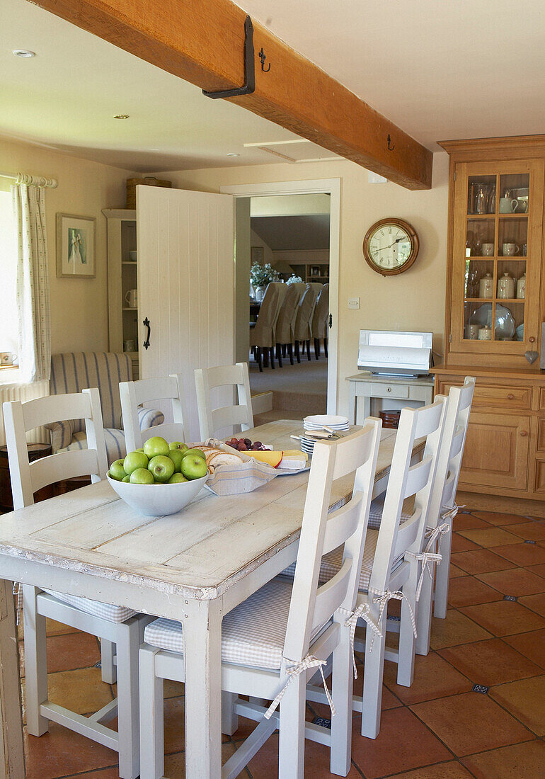 Weiß gestrichener Tisch und Stühle in einer Bauernhausküche mit Balken