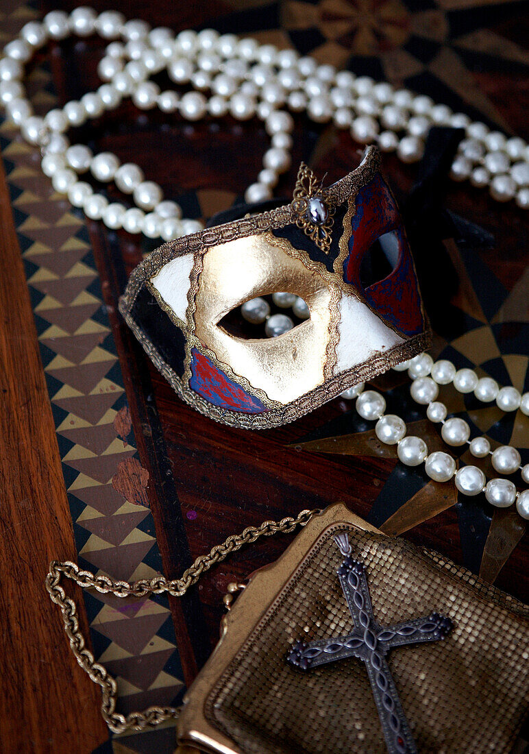 Venezianische Maske und Perlenkette mit goldener Handtasche aus Lametta