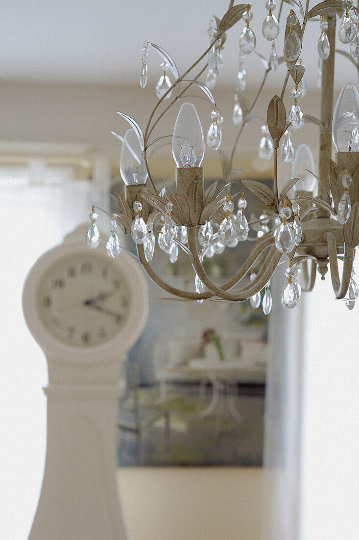 Kristalltropfen-Kronleuchter in einem Raum mit Gustavianischer Uhr