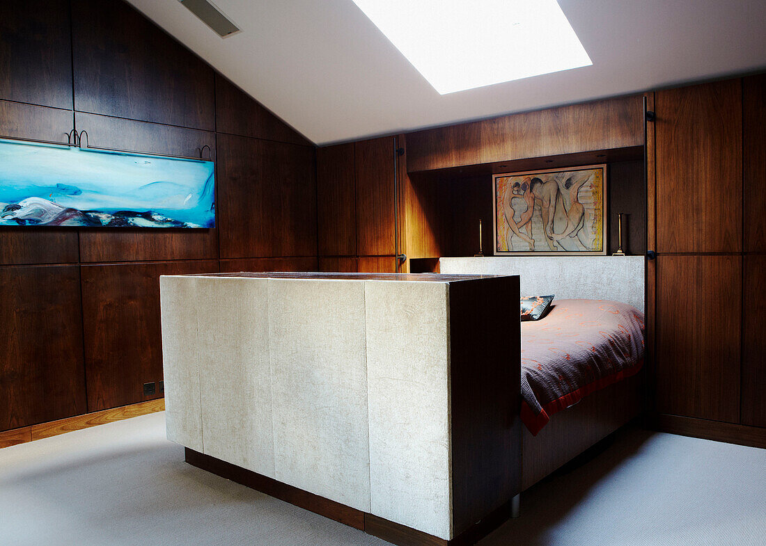 Modern art in panelled bedroom with skylight