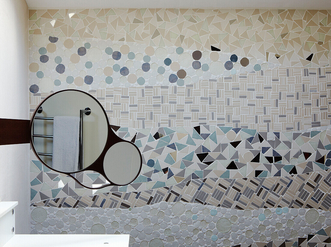 Rasierspiegel reflektiert Handtuchhalter in mosaikgefliestem Badezimmer