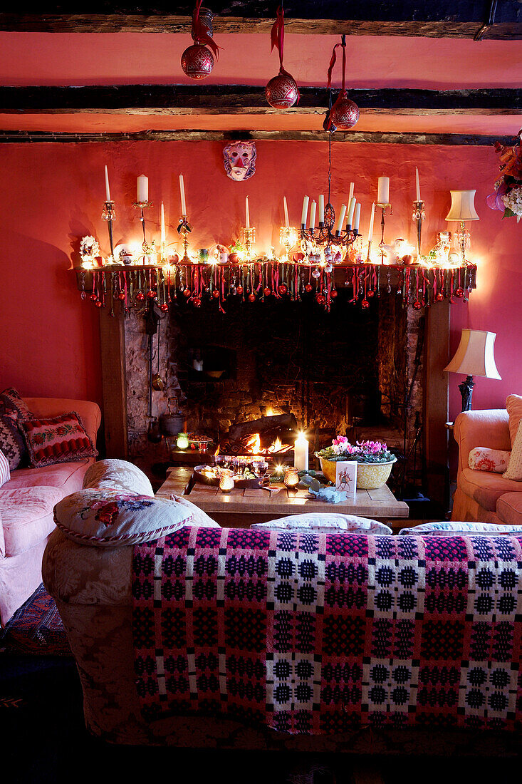 Beleuchtete Kerzen auf dem Kaminsims im Wohnzimmer eines walisischen Bauernhauses aus dem 16. Jh.