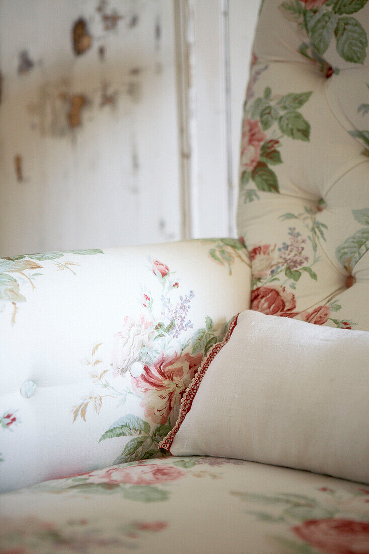 Buttoned down fabric on floral patterned armchair 
