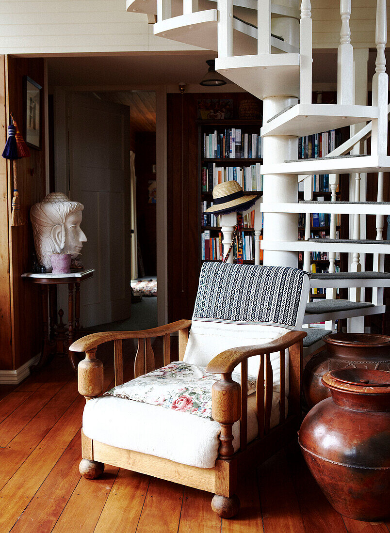 Armchair with bookcase under spiral staircase in Masterton New Zealand