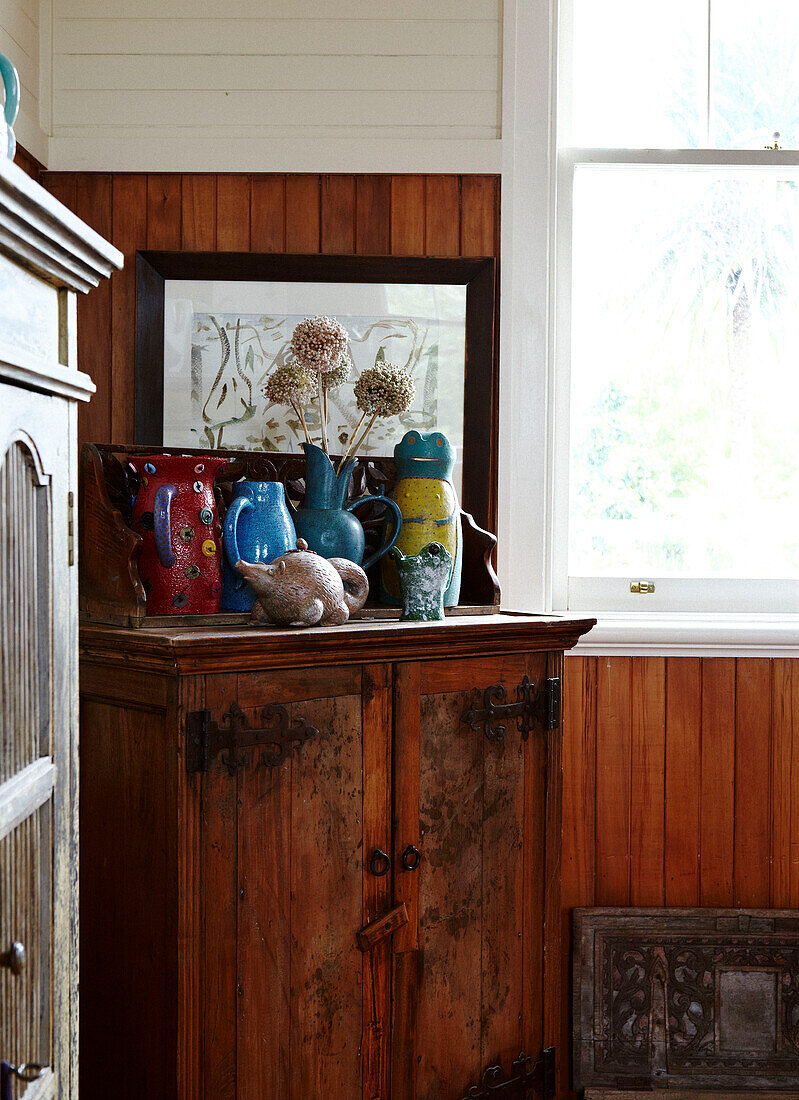 Sammlung von Töpferwaren auf einem Holzschrank in einem getäfelten Zimmer in Masterton, Neuseeland