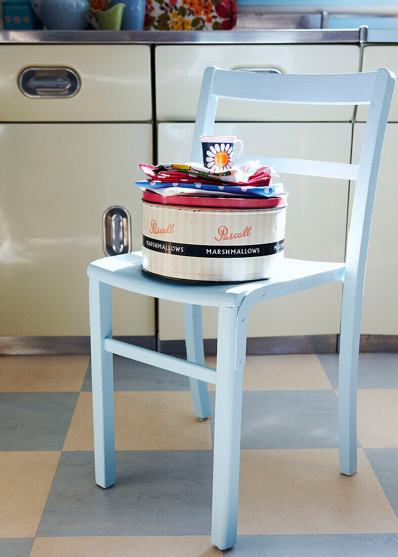 Küche aus den 1950er Jahren mit pastellblau lackiertem Stuhl und Kuchenform