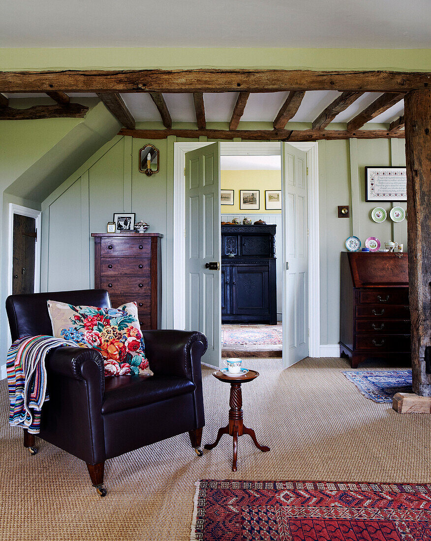 Ledersessel in einem Wohnzimmer mit Balken in Norfolk