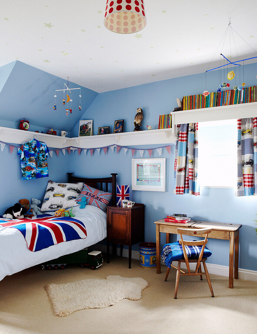 Hellblaues Jungenzimmer mit Union-Jack-Bettdecke und hohen Wandregalen