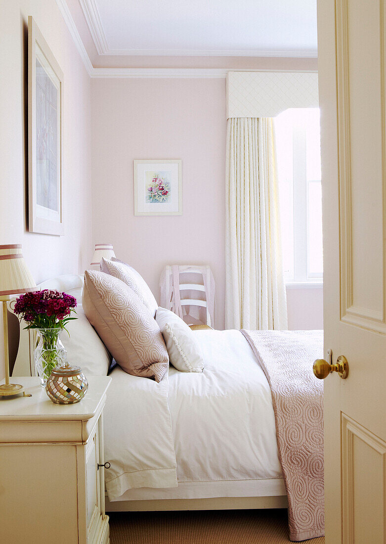 Pastellrosa Schlafzimmer mit Blick durch die Schlafzimmertür