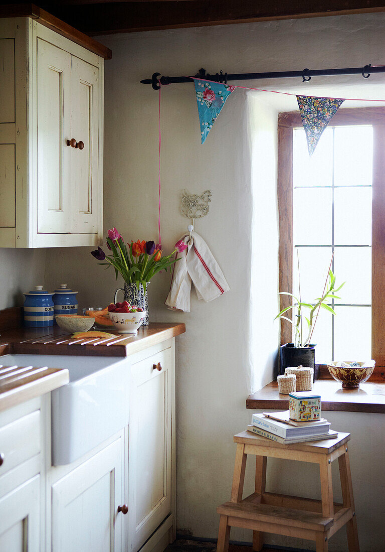 Sunlit window and butler sink in Devon cottage kitchen