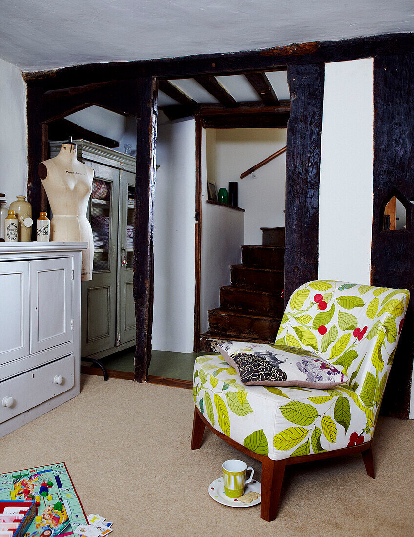 Sessel mit Blumendruck im Treppenhaus eines Cottages in Devon