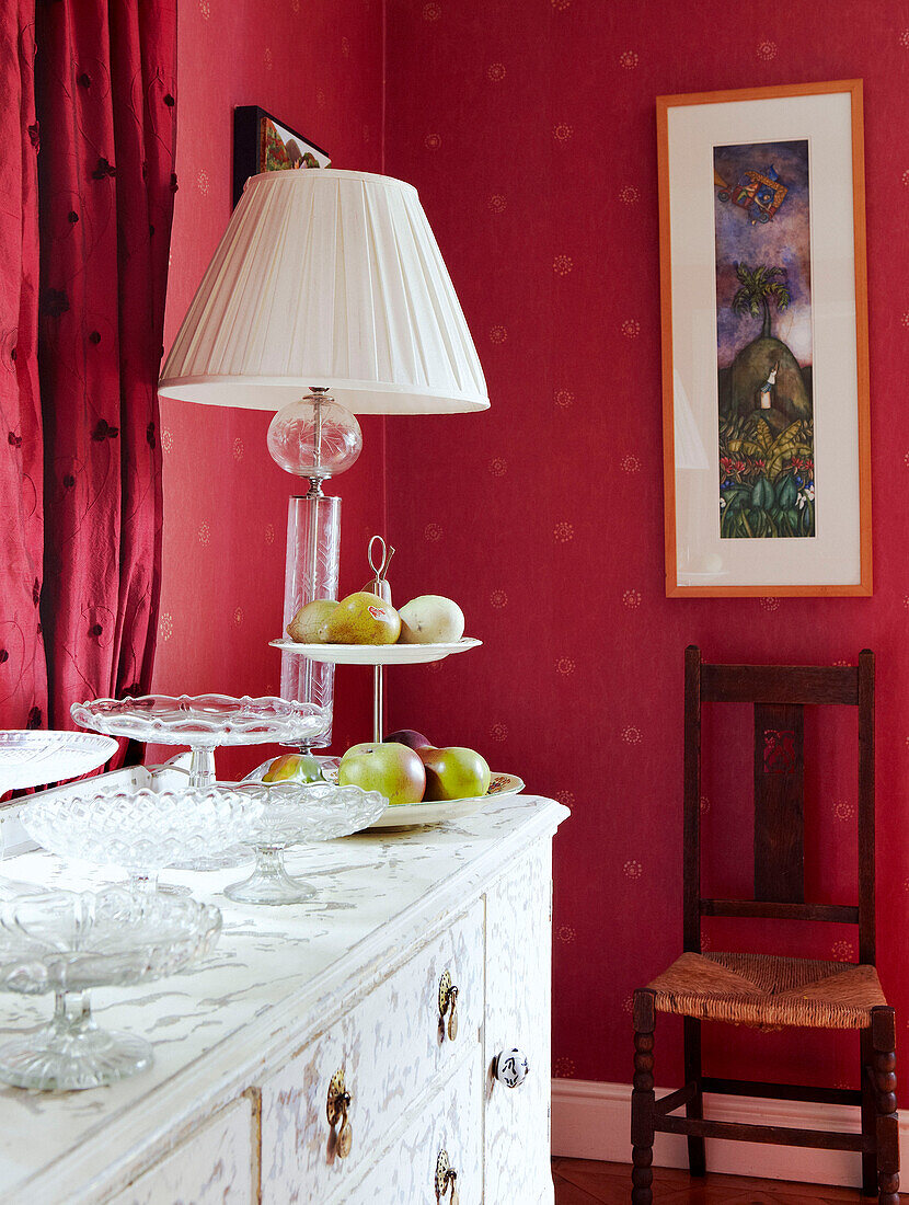 Lamp on sideboard in pink wallpapered dining room