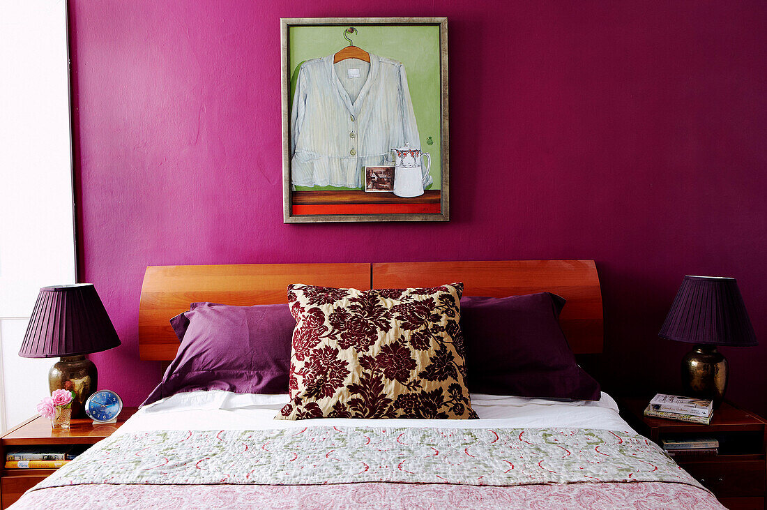Kunstwerk über dem Bett mit blumengemustertem Kissen