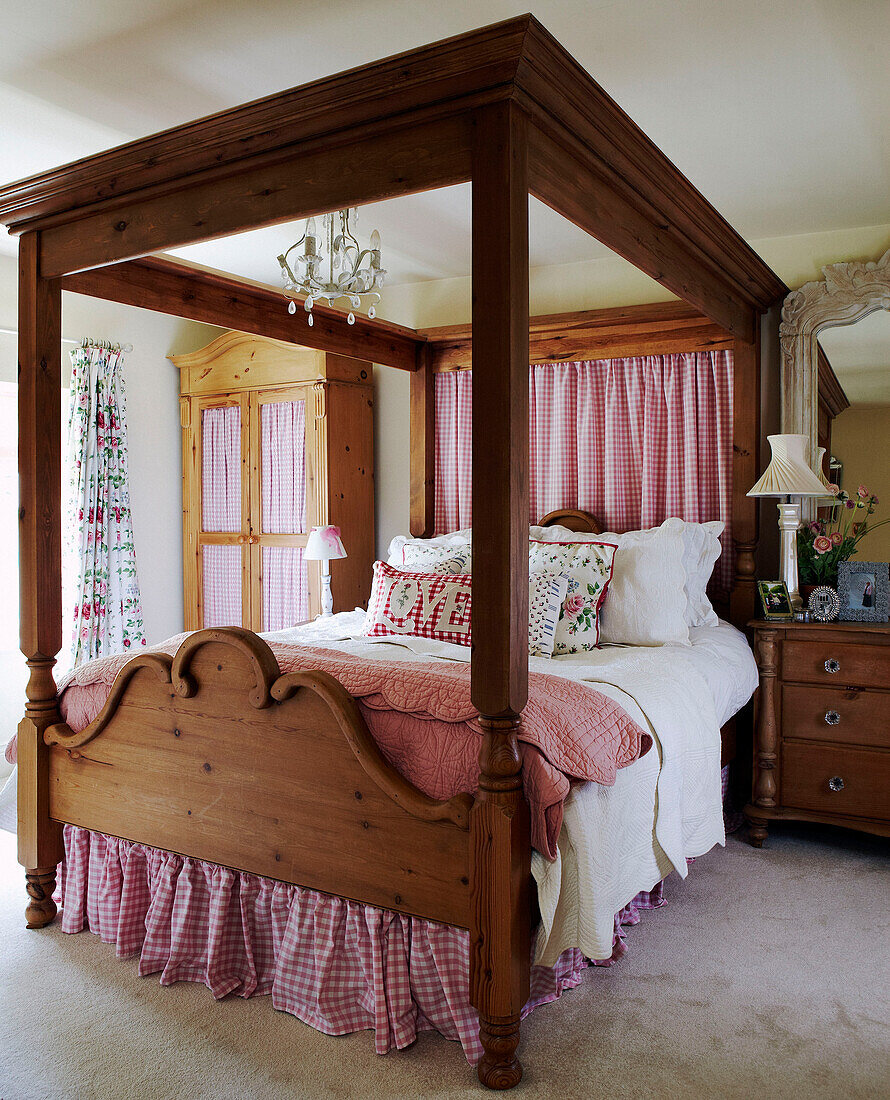 Wooden four poster bed with gingham checked fabric